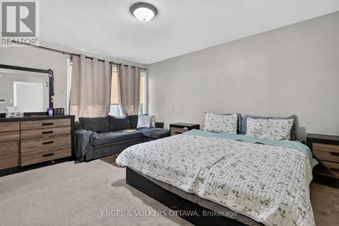 A bedroom with a large bed and a couch.