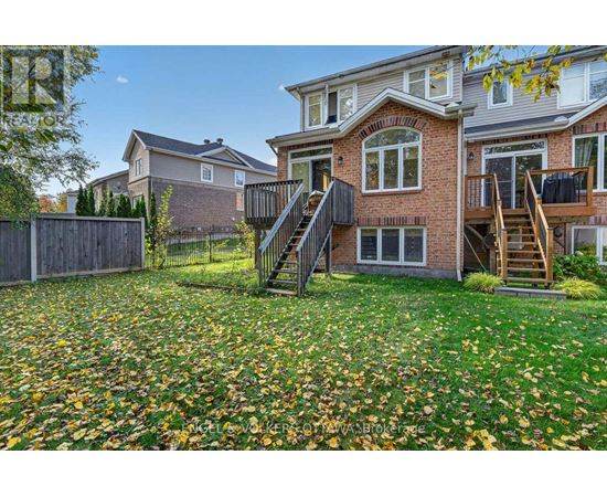 A house with a red brick exterior and a deck with a staircase.