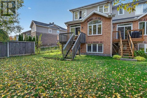 A house with a red brick exterior and a deck with a staircase.