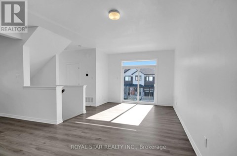 A spacious room with a view of a building through a window.