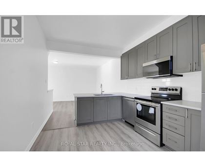 A kitchen with grey cabinets and stainless steel appliances.