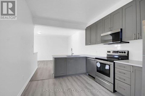 A kitchen with grey cabinets and stainless steel appliances.
