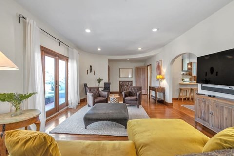 A living room with a grey sofa and yellow pillows.