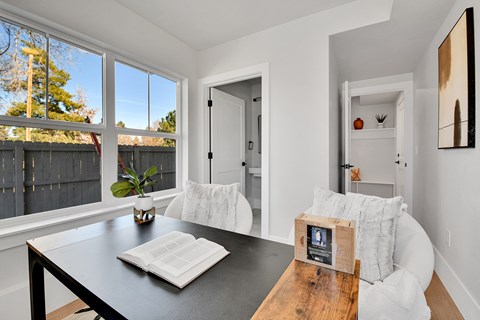 A modern dining room with a black table and white chairs.