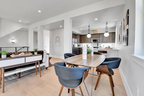 A modern dining room with a wooden table and chairs.