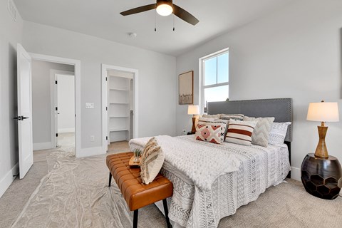 A bedroom with a large bed and a ceiling fan.