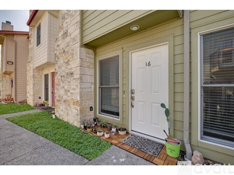 A house number 16 with a white door and a small garden in front.