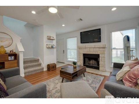 A living room with a fireplace and a television on the wall.