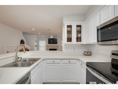 A modern kitchen with white cabinets and stainless steel appliances.
