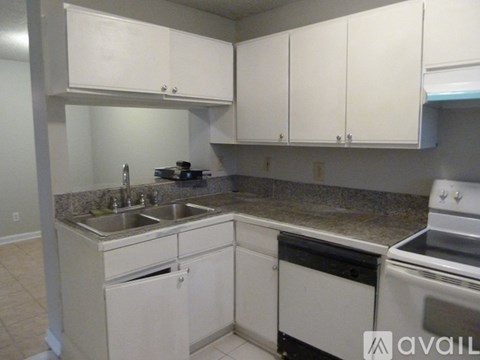 A kitchen with white cabinets and a stove top oven.