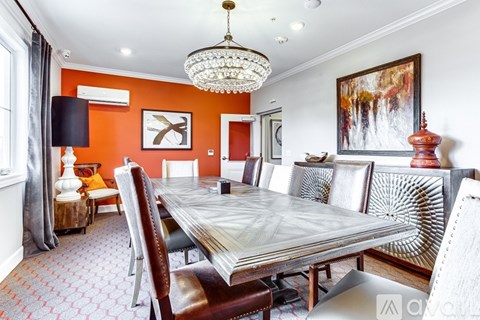 A dining room with a large table and chairs.