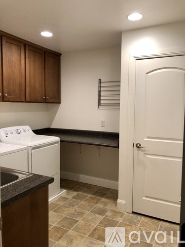 A kitchen with white appliances and brown cabinets.