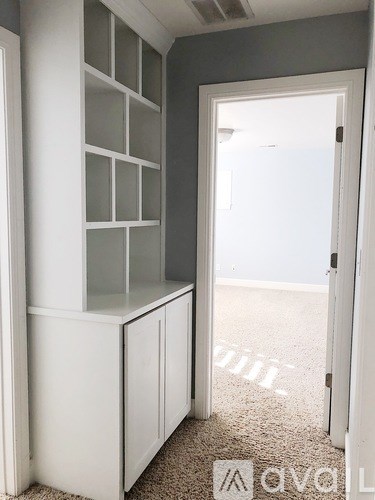 A white cabinet with glass block windows is in a room with a carpeted floor.