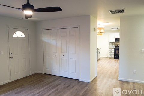 A room with a ceiling fan and a door with a window.