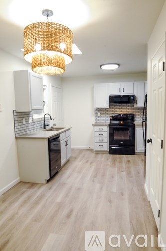 A kitchen with a white cabinet and a black stove top oven.