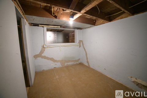 A room with a window and exposed ceiling beams.