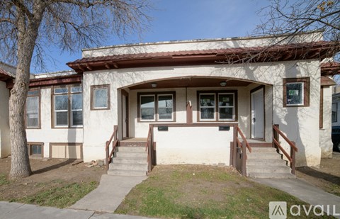 A house with a red tile roof and white walls is for sale.