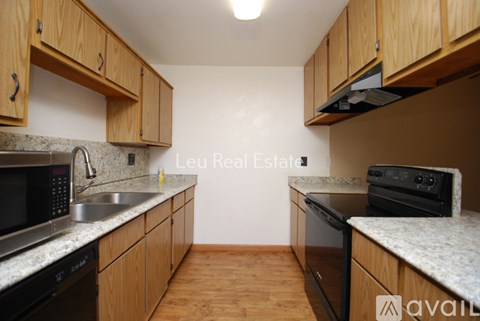 A kitchen with wooden cabinets and granite countertops.