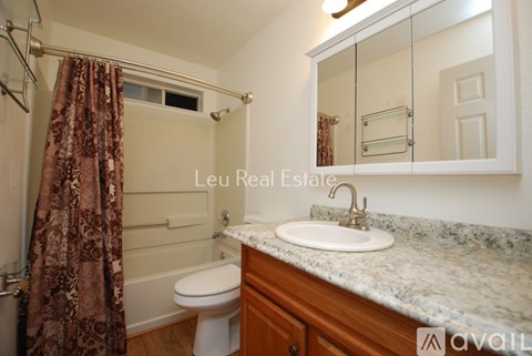 A bathroom with a toilet, sink, and shower.