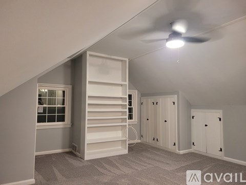 A room with a ceiling fan and a window with blinds.
