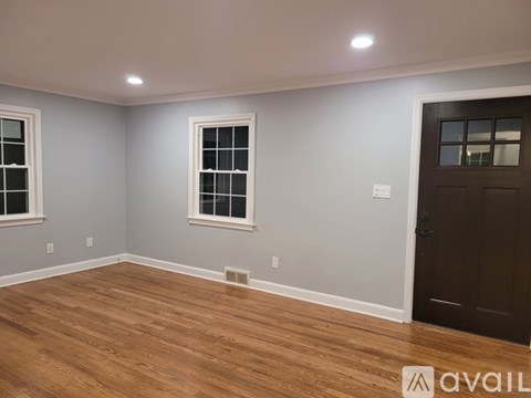 A room with wooden flooring and a brown door.