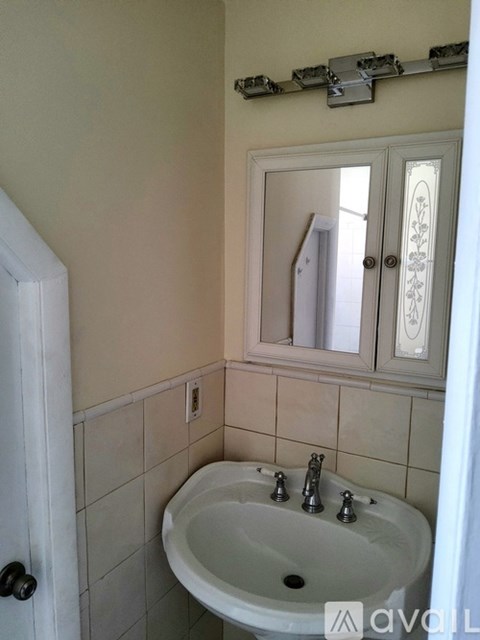 A bathroom with a white sink and a mirror above it.