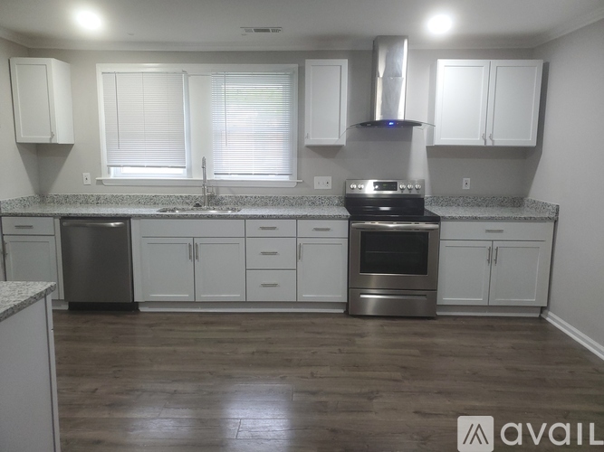 A kitchen with white cabinets and a stainless steel dishwasher.