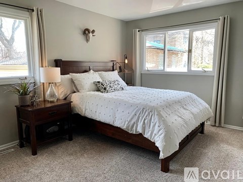 A bedroom with a bed, nightstand, and window.