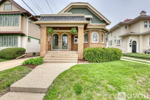 A house with a green lawn in front.