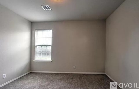 A room with a window and a carpeted floor.