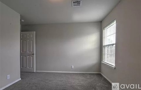 A room with a door and a window with blinds.