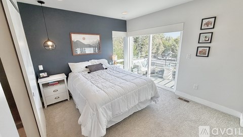 A bedroom with a large bed and a window overlooking a street.