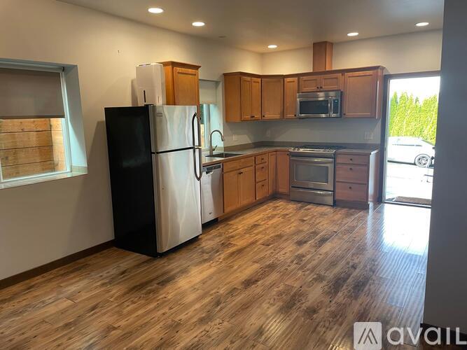 A kitchen with wooden cabinets and a black refrigerator.