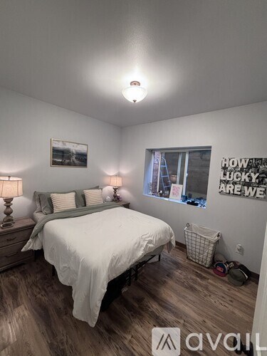 A bedroom with a bed, nightstand, and a poster on the wall.
