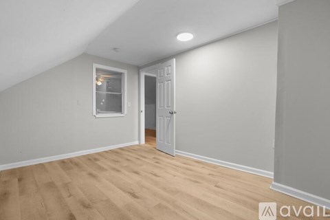 A room with wooden flooring and a window.
