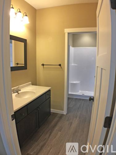 A bathroom with a sink, mirror, and a towel bar.