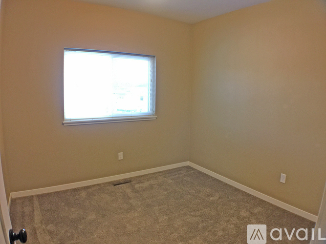 A room with a window and carpeted floor.