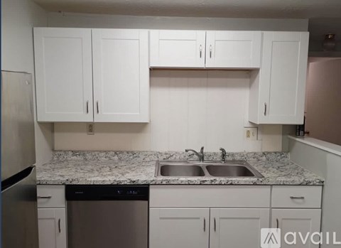 A kitchen with white cabinets and granite countertops.