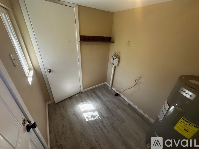 A room with a white door and a water heater.