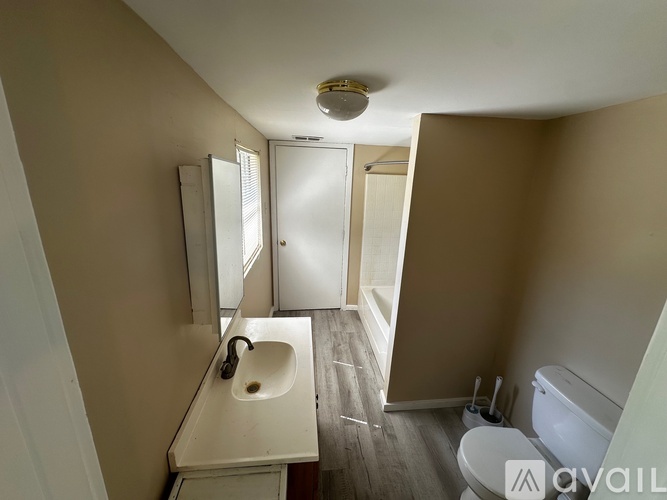 A bathroom with a sink, mirror, and toilet.