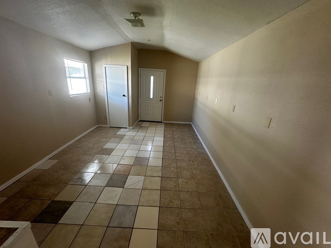 A room with tile flooring and two doors.