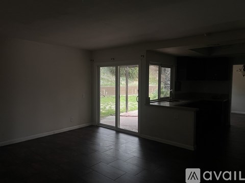 A room with a sliding glass door leading to a backyard.