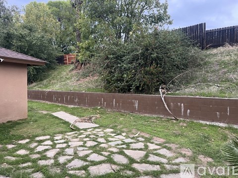 A backyard with a small building, a fence, and a garden.