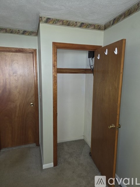 A room with two doors and a wall-mounted shelf.