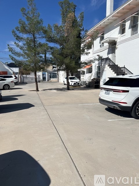 A white car is parked on a concrete driveway.