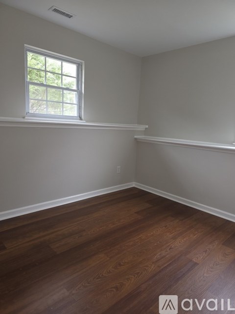 A room with wooden floors and a window.