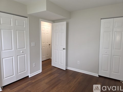 A room with white doors and wooden floors.