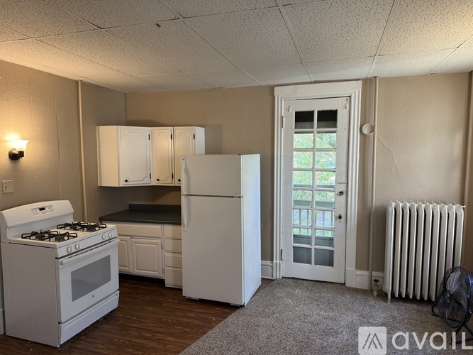 A kitchen with white appliances and a window.