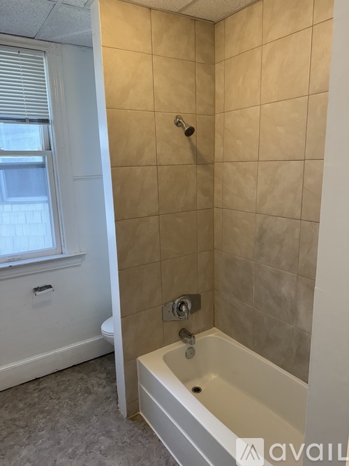 A bathroom with a tub and a window.