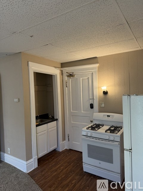 A kitchen with a white stove and a white refrigerator.
